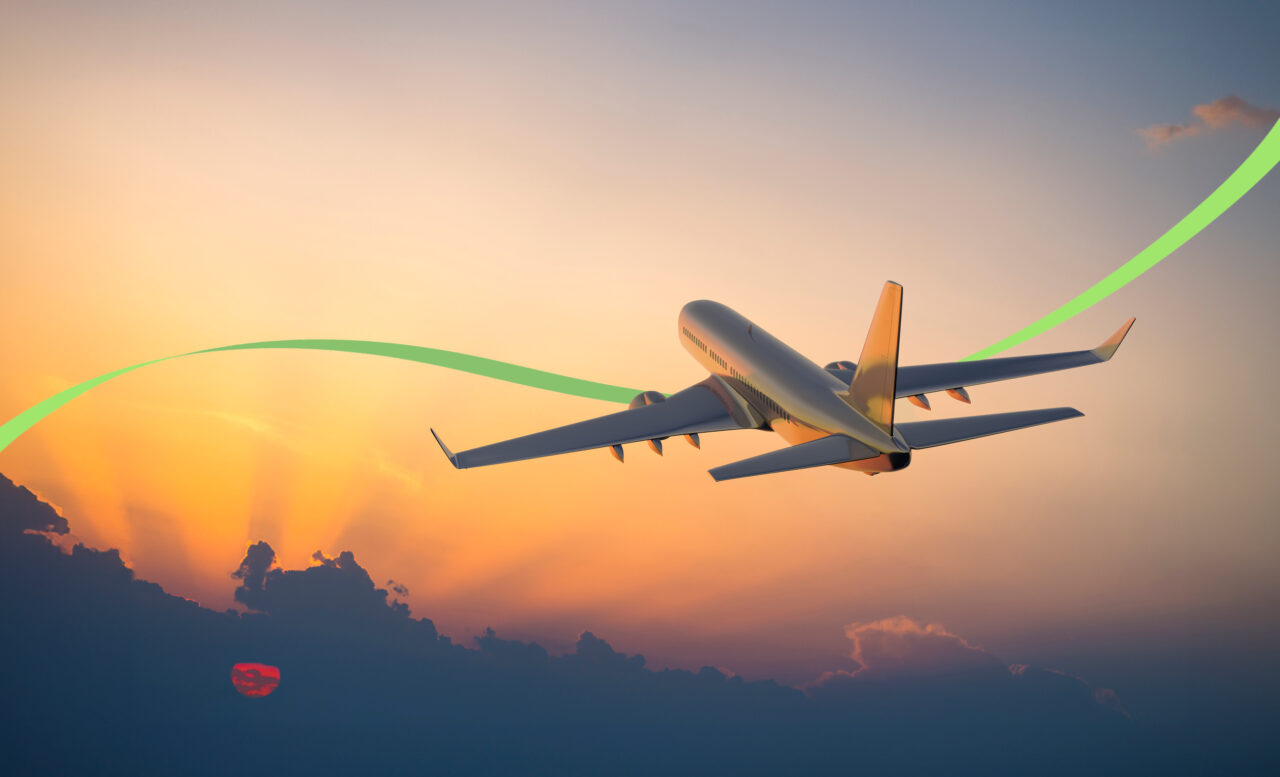 Passanger airplane flying in the sky with a setting sun behind a group of clouds